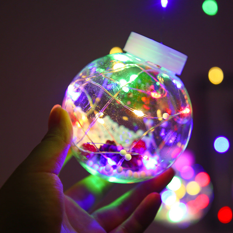 Lichtervorhang mit Weihnachtskugeln und Weihnachtsfiguren