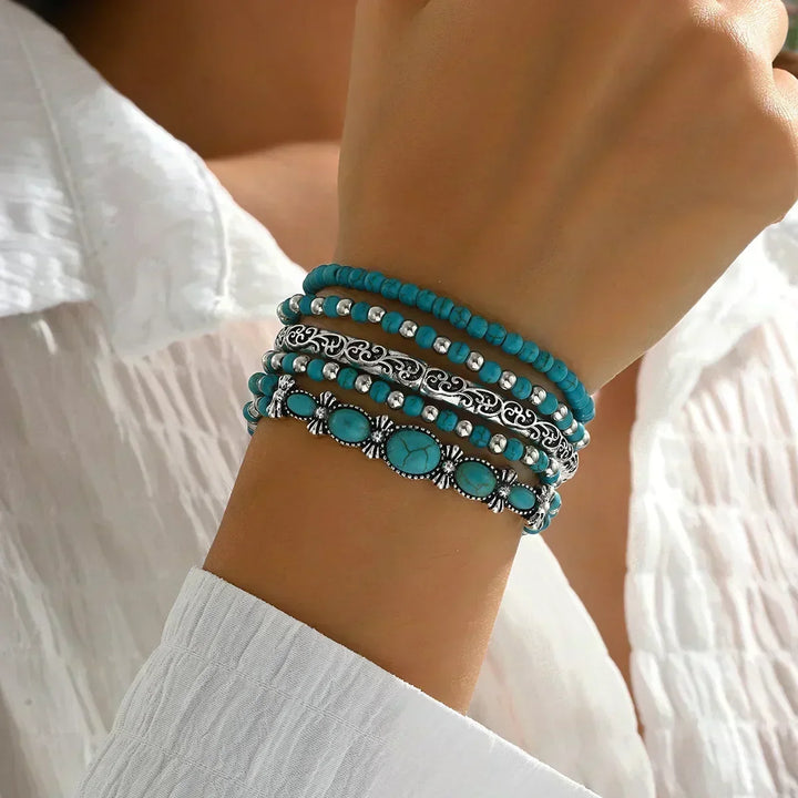 Set aus 5 Armbändern mit türkisfarbenen Perlen und silberfarbenen Details.